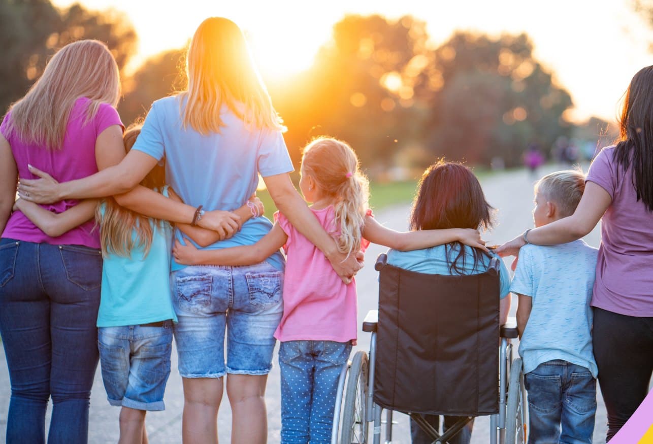 A family and their support network walking together at sunset