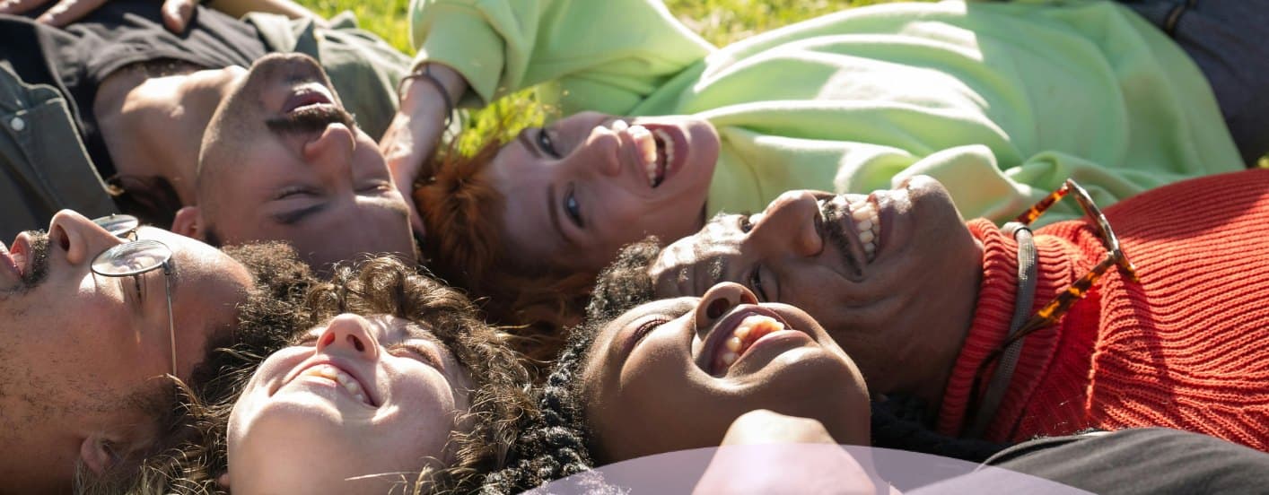 A diverse group of people smiling together outdoors